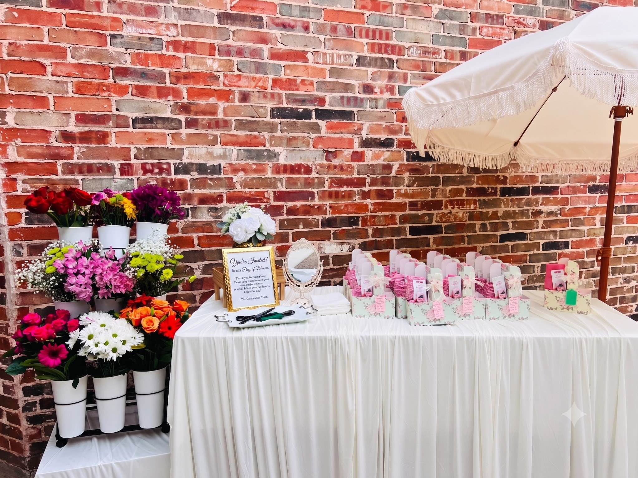 A second genuine Bloom Bar event setup showing the floral station, table arrangement, favors, and umbrella.