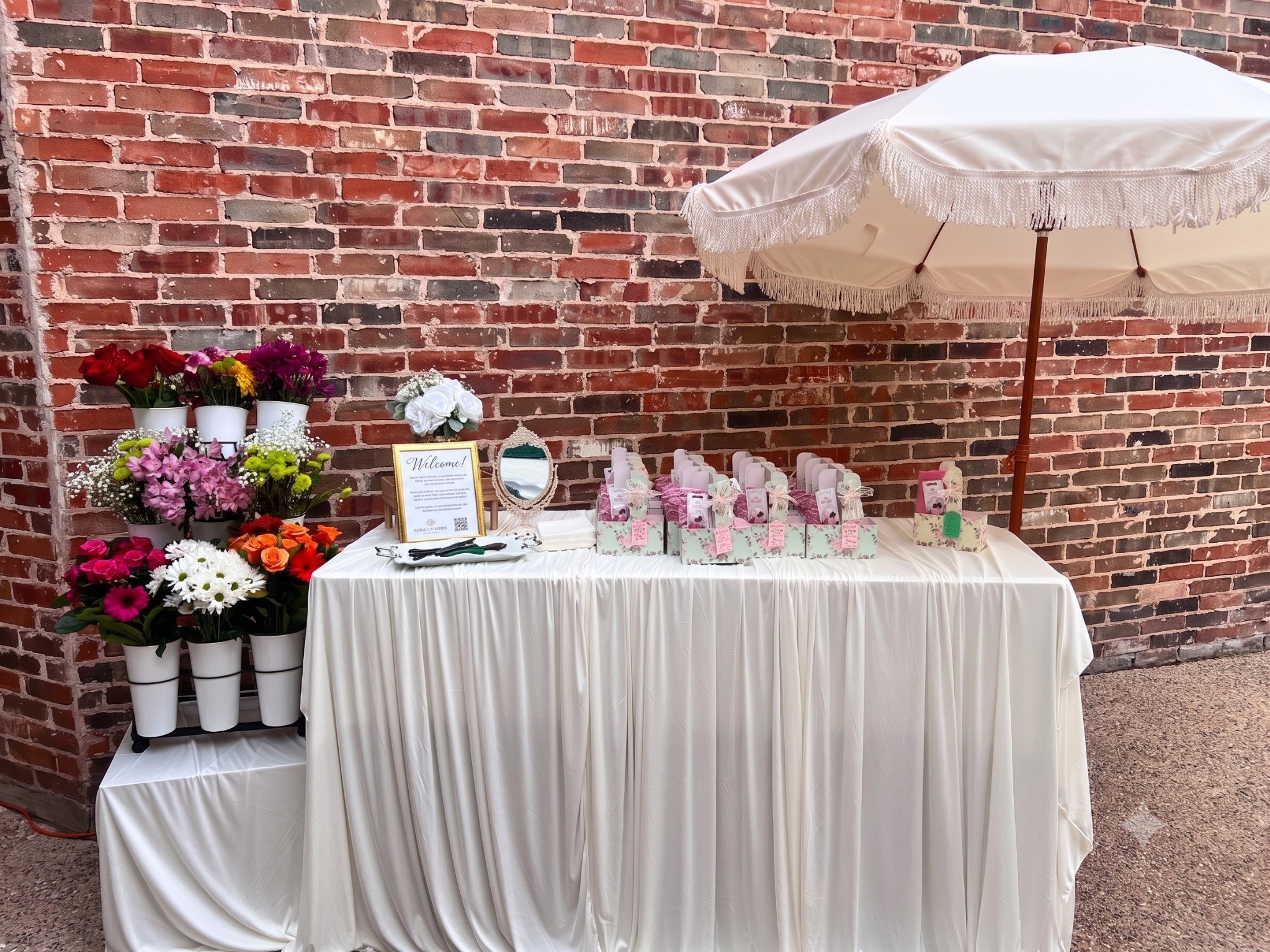 A genuine Zee Star Creations Bloom Bar event setup with flower display, table, favors, and umbrella.