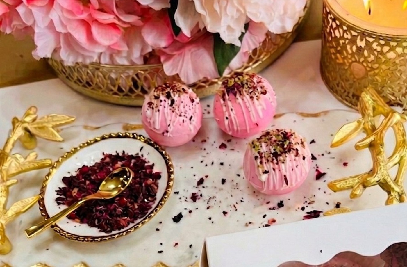 Kashmiri Chai Gems presented with rose petals and chai accessories.